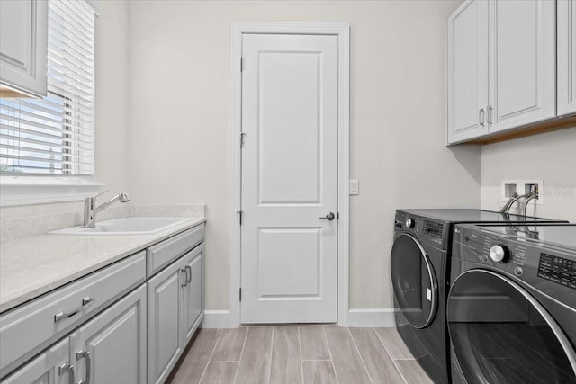 33750 Ocean Spray Ln, Wesley Chapel, FL 33543 - clothes washing area featuring washing machine and dryer, cabinet space, baseboards, and wood finish floors