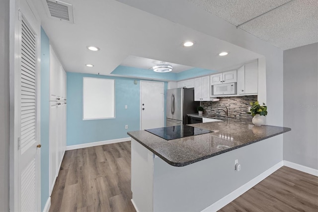 4904 38th Way S Unit 514, Saint Petersburg, FL 33711 - kitchen featuring freestanding refrigerator, black electric stovetop, white microwave, baseboards, and dark wood-style floors
