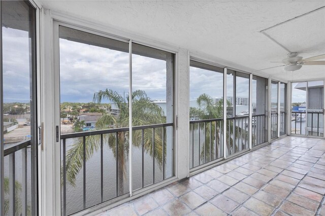 4904 38th Way S Unit 514, Saint Petersburg, FL 33711 - unfurnished sunroom with a wall of windows, a water view, healthy amount of natural light, a textured ceiling, and tile patterned floors