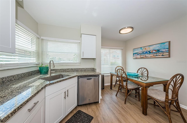 6151 Bahia Del Mar Blvd Unit 126, Saint Petersburg, FL 33715 - kitchen with dishwasher, a sink, light wood finished floors, light stone counters, and baseboards