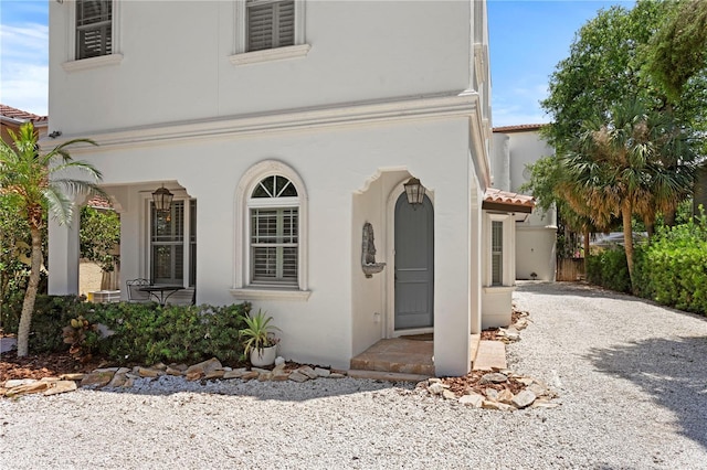 2936 W Knights Ave Unit A, Tampa, FL 33611 - view of front of home featuring stucco siding, covered porch, and gravel driveway