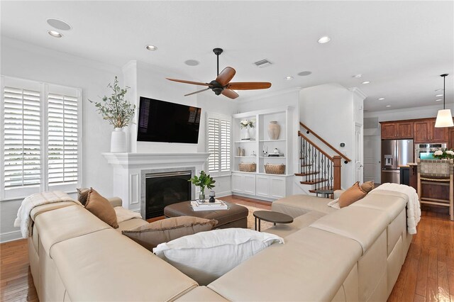 2936 W Knights Ave Unit A, Tampa, FL 33611 - living area with stairway, a ceiling fan, light wood finished floors, a fireplace, and crown molding