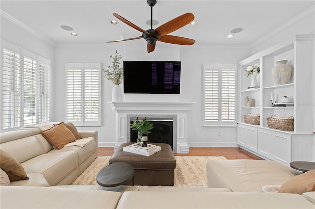 2936 W Knights Ave Unit A, Tampa, FL 33611 - living room with healthy amount of natural light, wood finished floors, a glass covered fireplace, ceiling fan, and ornamental molding