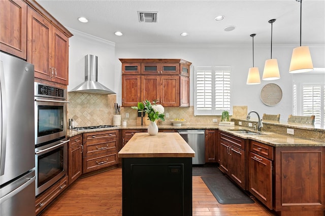 2936 W Knights Ave Unit A, Tampa, FL 33611 - kitchen featuring stainless steel appliances, wall chimney exhaust hood, a sink, butcher block countertops, and a peninsula