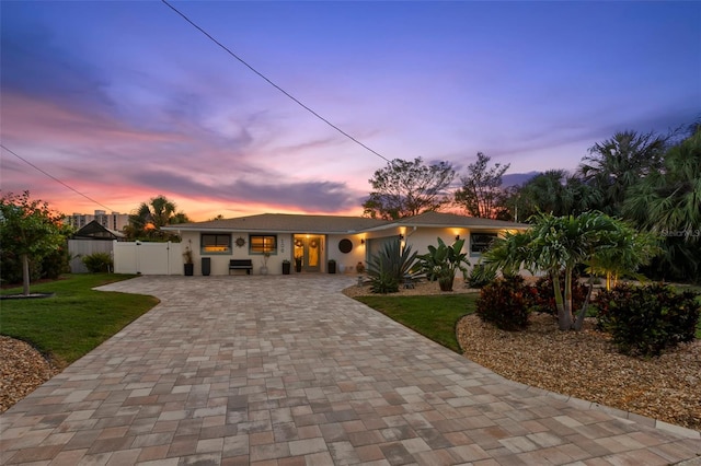 106 Midway Is, Clearwater Beach, FL 33767 - view of front facade featuring decorative driveway, stucco siding, and a gate