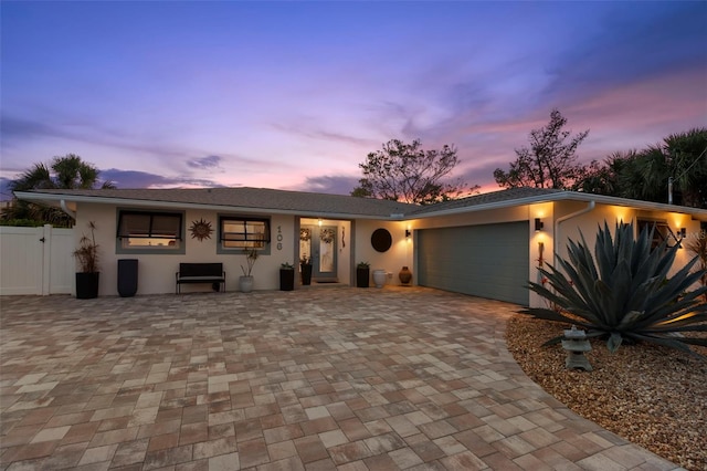 106 Midway Is, Clearwater Beach, FL 33767 - view of front of house with stucco siding, a garage, and decorative driveway