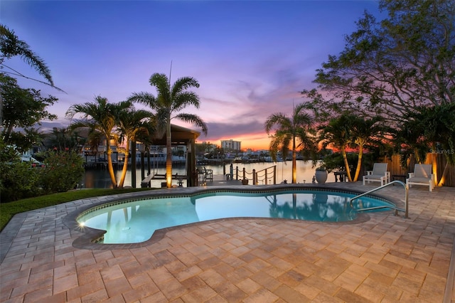 106 Midway Is, Clearwater Beach, FL 33767 - pool at dusk featuring an outdoor pool, a water view, and a patio area