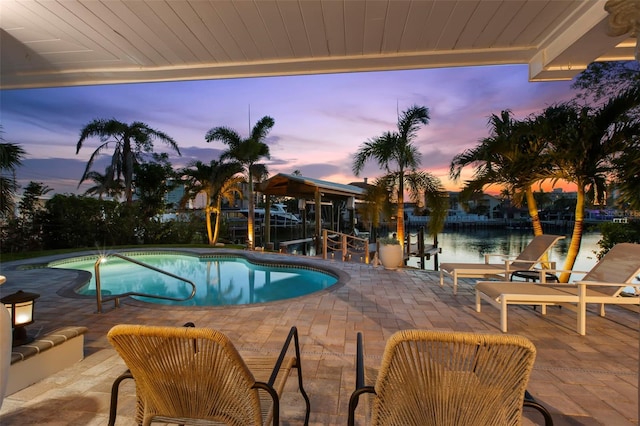 106 Midway Is, Clearwater Beach, FL 33767 - pool at dusk with a patio area, an outdoor pool, and a water view