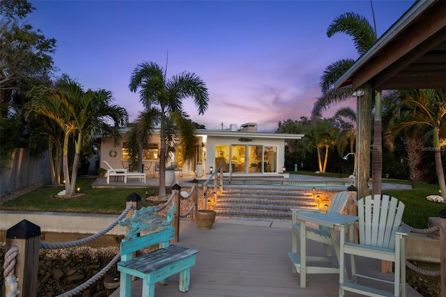 106 Midway Is, Clearwater Beach, FL 33767 - deck at dusk with an outdoor pool and a lawn