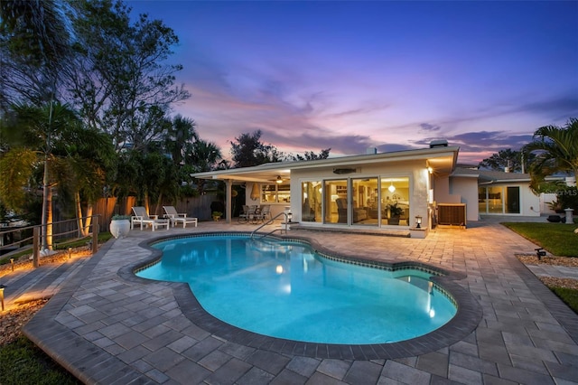 106 Midway Is, Clearwater Beach, FL 33767 - pool at dusk featuring a patio, an outdoor pool, and ceiling fan