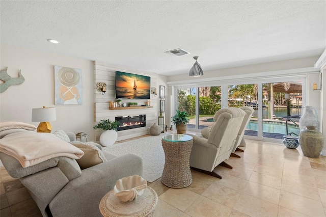 106 Midway Is, Clearwater Beach, FL 33767 - living area with a textured ceiling, a glass covered fireplace, recessed lighting, and light tile patterned flooring
