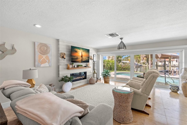106 Midway Is, Clearwater Beach, FL 33767 - living area featuring a textured ceiling, a glass covered fireplace, recessed lighting, and light tile patterned floors