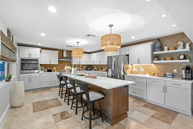 106 Midway Is, Clearwater Beach, FL 33767 - kitchen featuring appliances with stainless steel finishes, wall chimney exhaust hood, recessed lighting, decorative backsplash, and light countertops