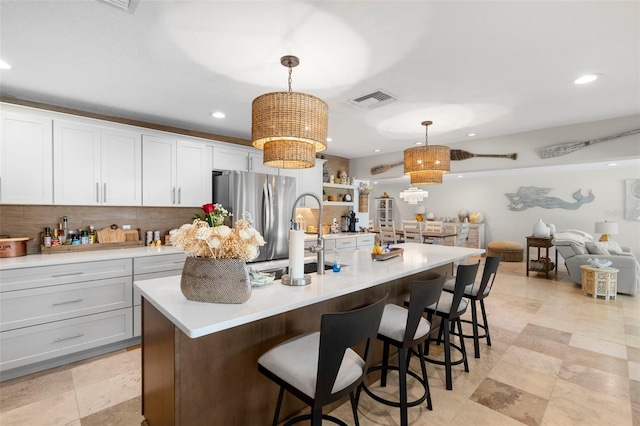 106 Midway Is, Clearwater Beach, FL 33767 - kitchen featuring freestanding refrigerator, light countertops, recessed lighting, decorative light fixtures, and a kitchen breakfast bar