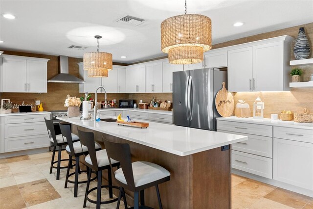 106 Midway Is, Clearwater Beach, FL 33767 - kitchen featuring wall chimney exhaust hood, freestanding refrigerator, decorative backsplash, and recessed lighting