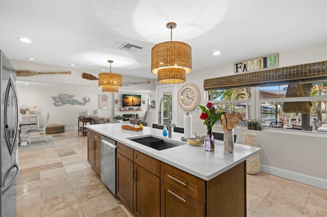 106 Midway Is, Clearwater Beach, FL 33767 - kitchen with appliances with stainless steel finishes, open floor plan, light countertops, an island with sink, and hanging light fixtures