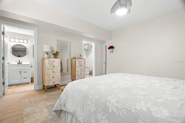 106 Midway Is, Clearwater Beach, FL 33767 - bedroom featuring light wood-style floors, a walk in closet, ensuite bath, a closet, and ceiling fan