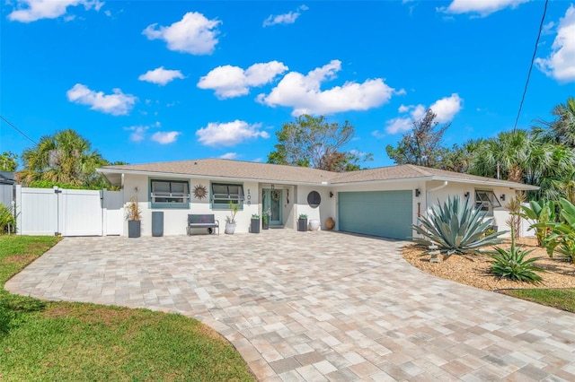 106 Midway Is, Clearwater Beach, FL 33767 - ranch-style home featuring a gate, stucco siding, a garage, and decorative driveway