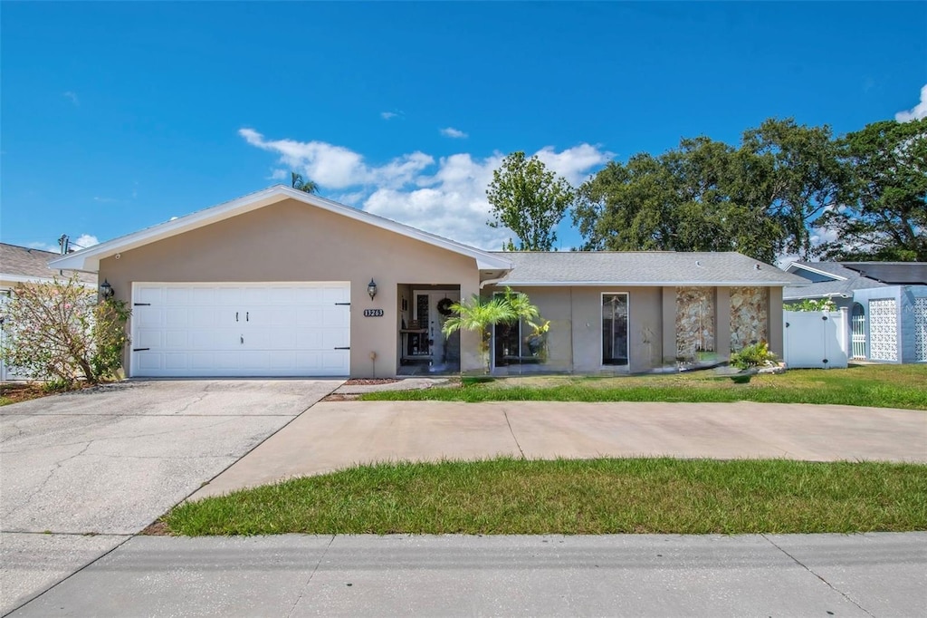 13263 86th Ave, Seminole, FL 33776 - single story home featuring a garage, stucco siding, concrete driveway, and fence