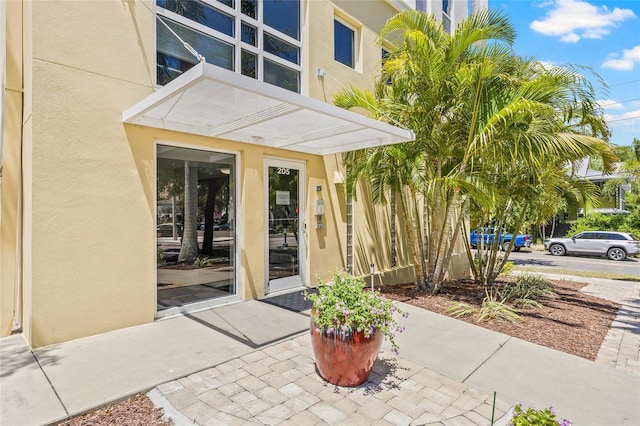 view of exterior entry featuring stucco siding