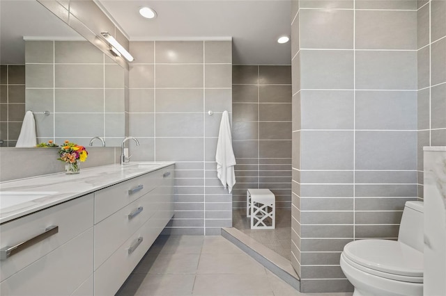 full bath with tile walls, toilet, tile patterned floors, double vanity, and recessed lighting