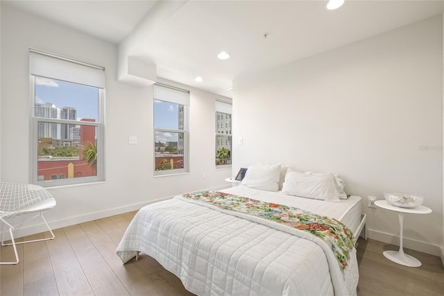bedroom featuring wood finished floors, recessed lighting, and baseboards
