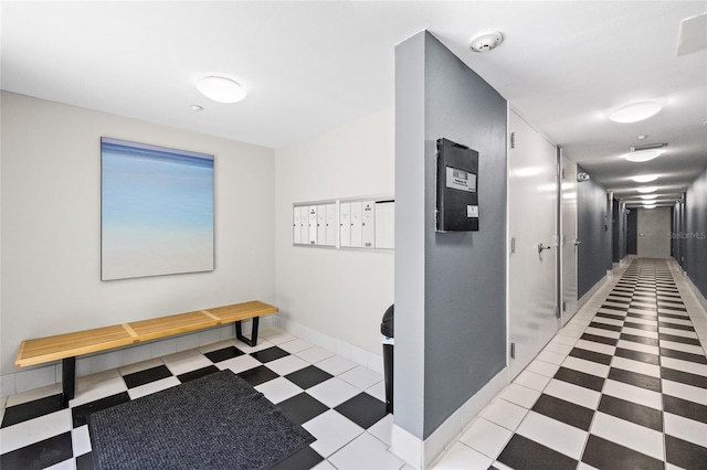 hall with light floors, baseboards, and mail area