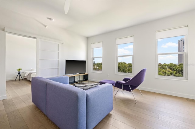 living area with baseboards and wood finished floors