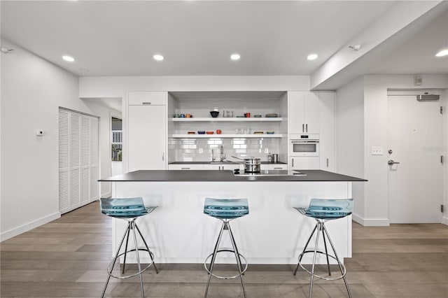 205 5th Ave N Unit 501, Saint Petersburg, FL 33701 - bar with oven, baseboards, light wood-style flooring, recessed lighting, and black electric cooktop