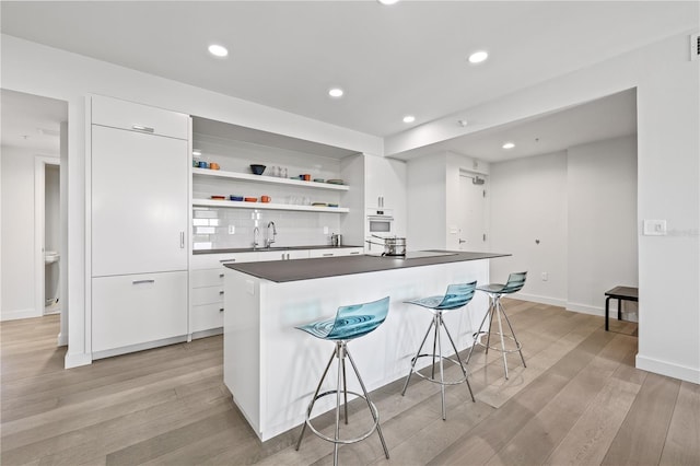 205 5th Ave N Unit 501, Saint Petersburg, FL 33701 - kitchen with dark countertops, open shelves, white cabinets, and recessed lighting