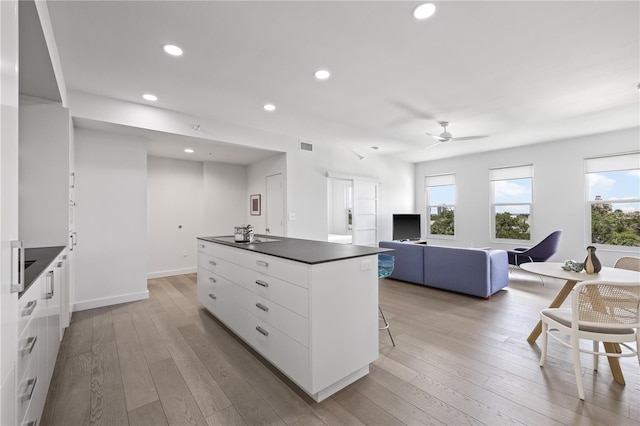 205 5th Ave N Unit 501, Saint Petersburg, FL 33701 - kitchen with dark countertops, white cabinetry, a center island, light wood-style floors, and ceiling fan