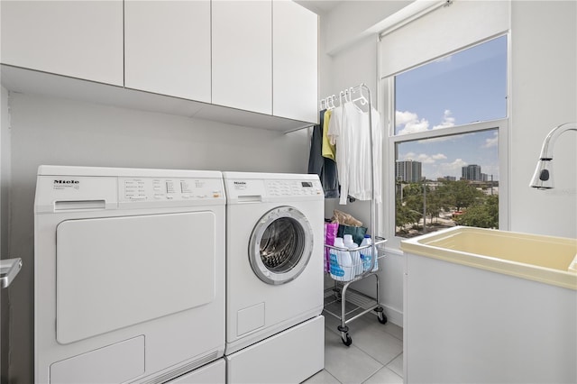 205 5th Ave N Unit 501, Saint Petersburg, FL 33701 - laundry room with cabinet space, washer and dryer, light tile patterned flooring, baseboards, and a view of city