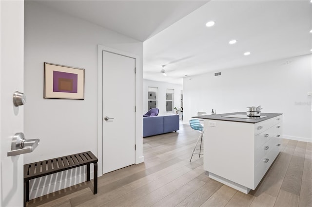205 5th Ave N Unit 501, Saint Petersburg, FL 33701 - kitchen with white cabinetry, a breakfast bar area, dark countertops, a ceiling fan, and recessed lighting