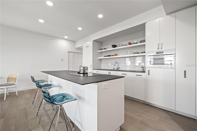 205 5th Ave N Unit 501, Saint Petersburg, FL 33701 - kitchen featuring black electric cooktop, dark countertops, open shelves, a kitchen breakfast bar, and recessed lighting