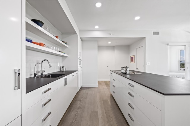 205 5th Ave N Unit 501, Saint Petersburg, FL 33701 - kitchen featuring dark countertops, a sink, modern cabinets, recessed lighting, and white cabinets