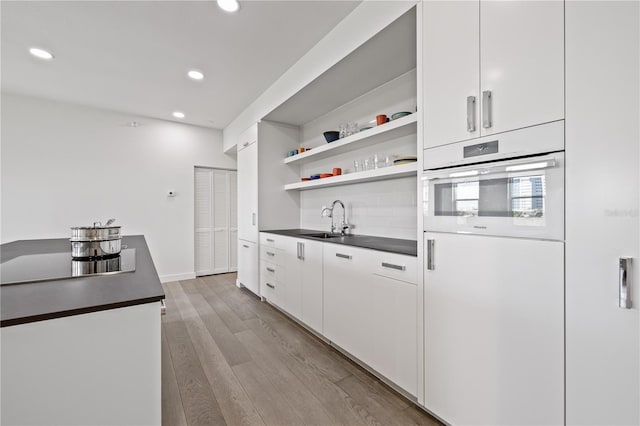 205 5th Ave N Unit 501, Saint Petersburg, FL 33701 - kitchen with a sink, dark countertops, open shelves, recessed lighting, and white cabinetry