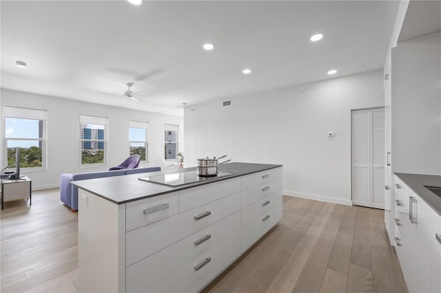 205 5th Ave N Unit 501, Saint Petersburg, FL 33701 - kitchen featuring modern cabinets, a ceiling fan, black electric stovetop, white cabinets, and light wood-style flooring