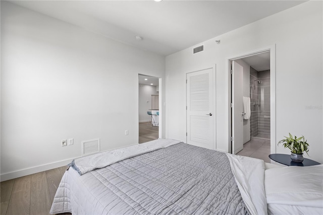 205 5th Ave N Unit 501, Saint Petersburg, FL 33701 - bedroom with baseboards, wood finished floors, connected bathroom, and recessed lighting