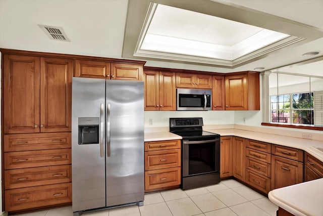 14561 El Paseo Dr, Seminole, FL 33776 - kitchen featuring appliances with stainless steel finishes, brown cabinets, light tile patterned flooring, light countertops, and ornamental molding