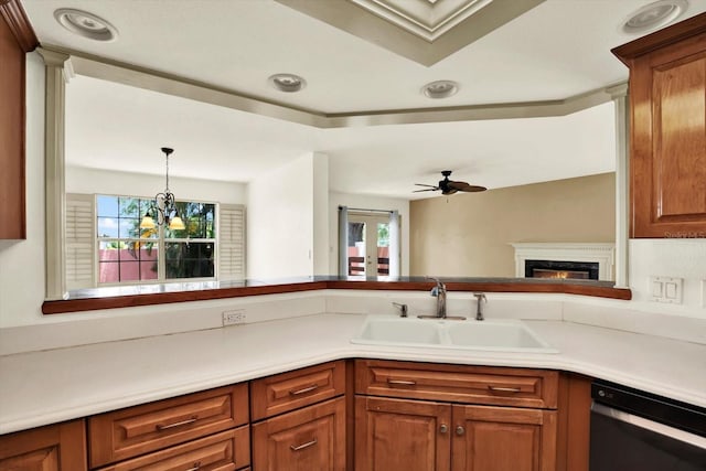 14561 El Paseo Dr, Seminole, FL 33776 - kitchen featuring dishwashing machine, a sink, brown cabinets, a lit fireplace, and light countertops