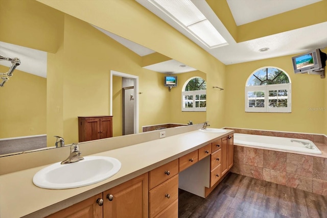 14561 El Paseo Dr, Seminole, FL 33776 - full bath with wood finished floors, a garden tub, double vanity, and a stall shower