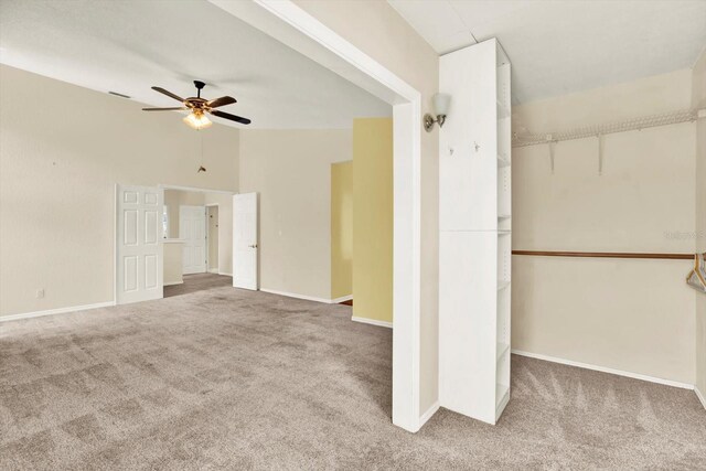 14561 El Paseo Dr, Seminole, FL 33776 - unfurnished living room featuring carpet flooring, ceiling fan, baseboards, and lofted ceiling