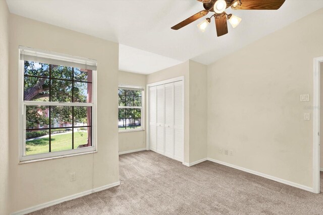 14561 El Paseo Dr, Seminole, FL 33776 - unfurnished bedroom with carpet, baseboards, a closet, and ceiling fan
