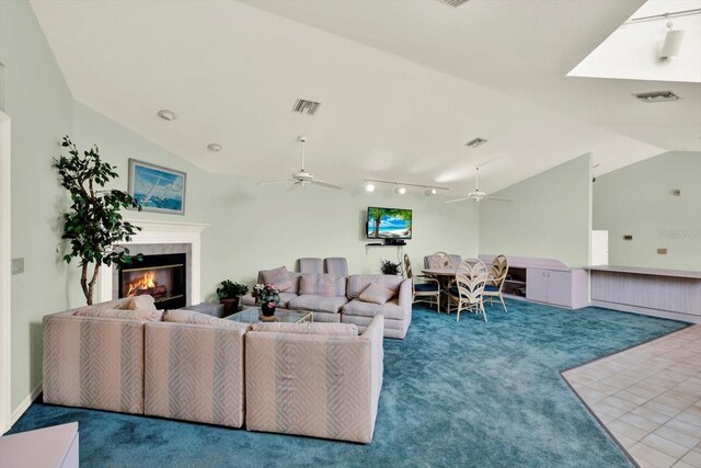 14561 El Paseo Dr, Seminole, FL 33776 - living area featuring carpet, lofted ceiling, ceiling fan, and a glass covered fireplace