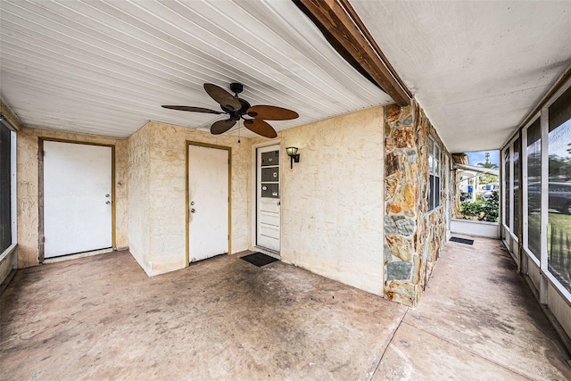 unfurnished sunroom with ceiling fan