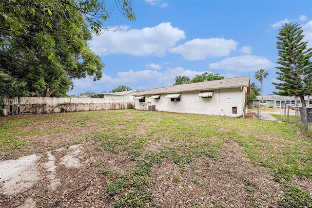 rear view of property featuring a gate and stucco siding