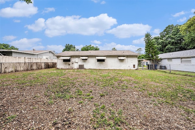 rear view of house with stucco siding and cooling unit