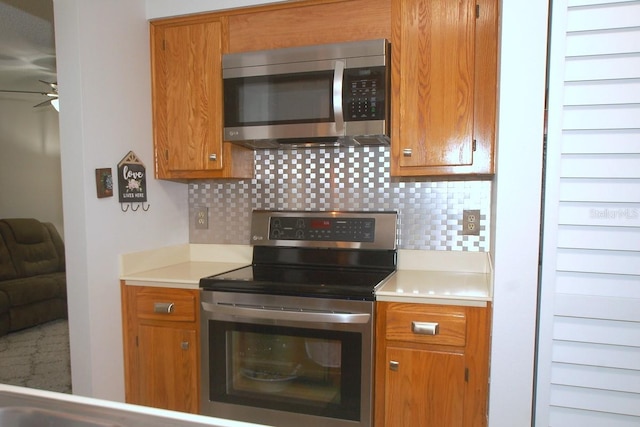 1126 Tarridon Ct, Dunedin, FL 34698 - kitchen with stainless steel appliances, decorative backsplash, ceiling fan, and light countertops
