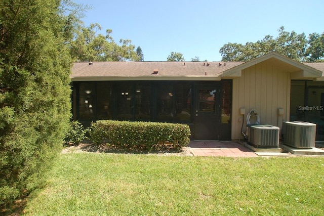 1126 Tarridon Ct, Dunedin, FL 34698 - back of property featuring cooling unit and a lawn