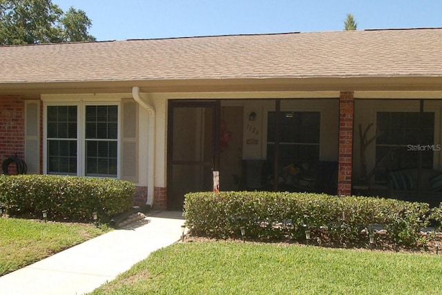 1126 Tarridon Ct, Dunedin, FL 34698 - view of exterior entry with brick siding and a shingled roof
